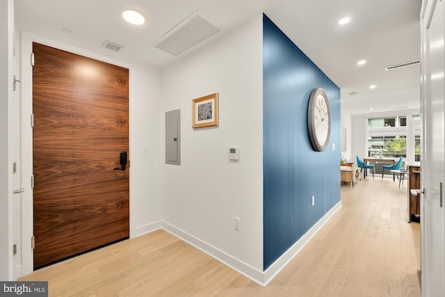 hallway with electric panel and light hardwood / wood-style floors