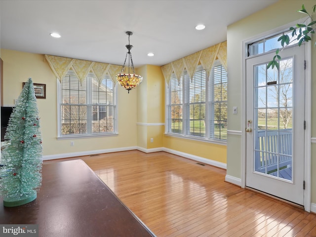 unfurnished dining area featuring wood-type flooring and a chandelier