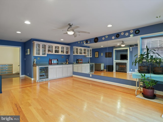 interior space featuring white cabinetry, light hardwood / wood-style floors, beverage cooler, and ceiling fan