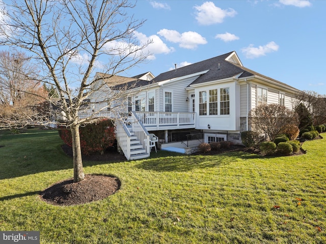 rear view of house with a wooden deck and a yard