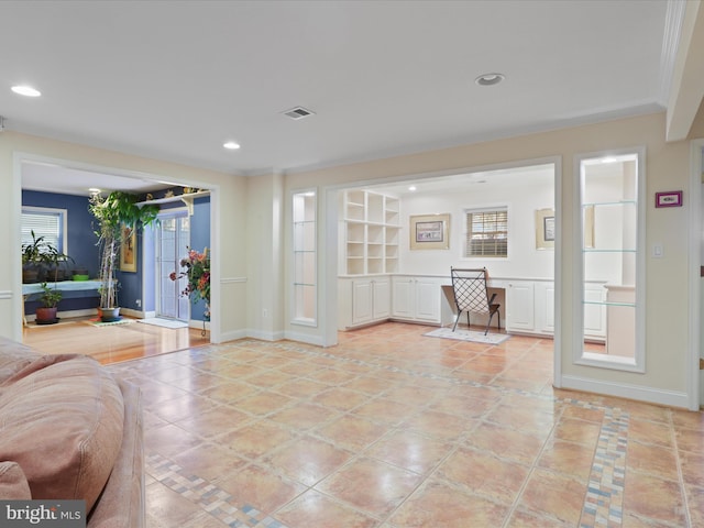 interior space featuring ornamental molding, built in desk, and light tile patterned floors