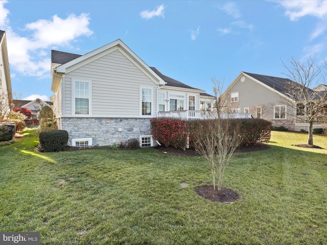 rear view of property featuring a lawn