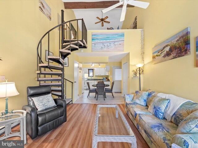 living room featuring beamed ceiling, high vaulted ceiling, light hardwood / wood-style flooring, and ceiling fan