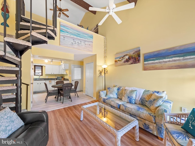 living room with high vaulted ceiling, sink, ceiling fan, beam ceiling, and light hardwood / wood-style floors