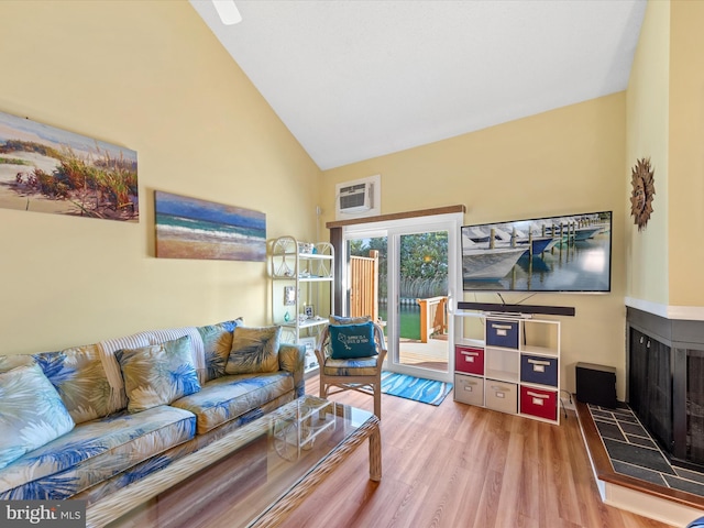 living room featuring light hardwood / wood-style floors, a fireplace, and high vaulted ceiling