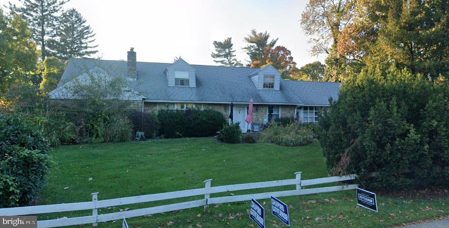 cape cod house featuring a front yard