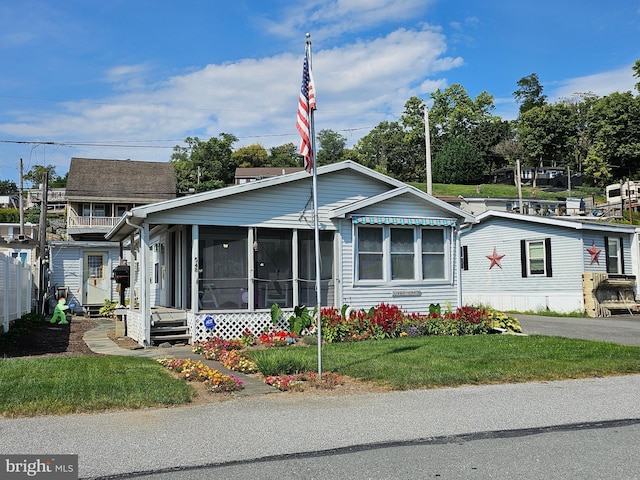 view of front facade featuring a front lawn and a sunroom