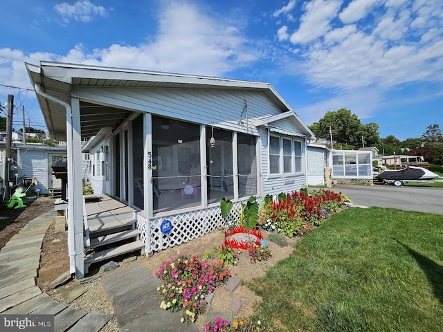 exterior space featuring a front yard and a sunroom