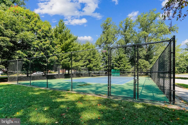 view of tennis court featuring a yard