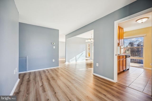 unfurnished room featuring light hardwood / wood-style floors and a chandelier