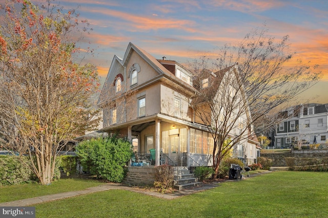 property exterior at dusk with a lawn