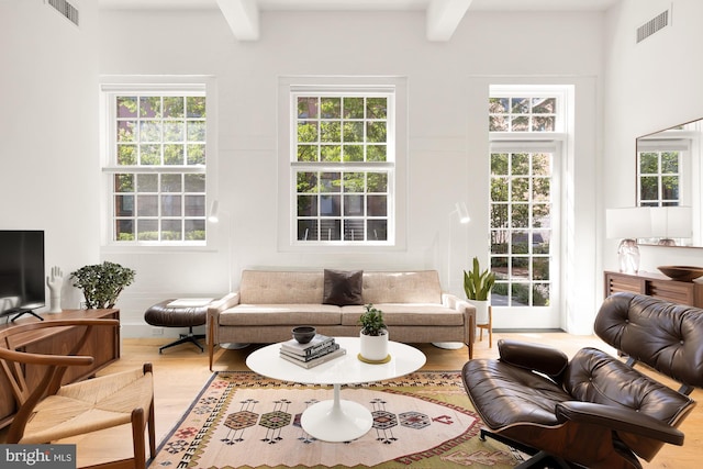 living room featuring beamed ceiling and hardwood / wood-style floors