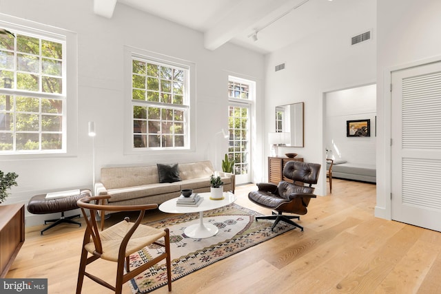 sitting room with beam ceiling and light wood-type flooring