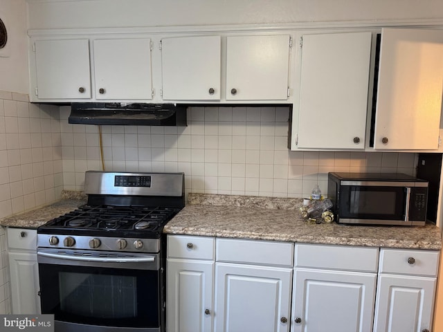 kitchen with decorative backsplash, white cabinets, stainless steel appliances, and ventilation hood