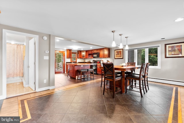 tiled dining room with a baseboard heating unit