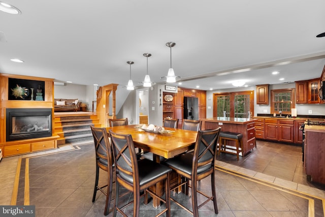 dining area featuring tile patterned flooring, a large fireplace, and sink