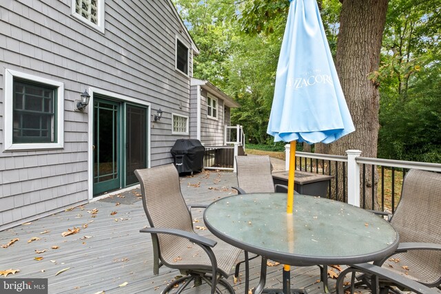 wooden deck featuring a grill