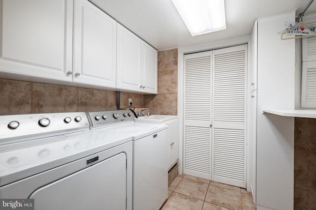 laundry room featuring cabinets, separate washer and dryer, sink, and light tile patterned floors