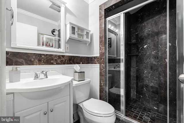 bathroom featuring ornamental molding, vanity, toilet, and a shower with shower door