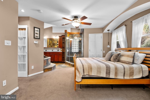 bedroom featuring connected bathroom, ceiling fan, a closet, and light carpet