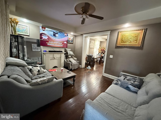 living room featuring ceiling fan and dark hardwood / wood-style floors