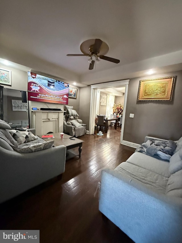 living room with ceiling fan and dark wood-type flooring