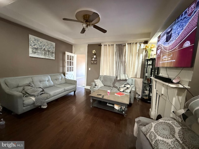 living room with ceiling fan and dark wood-type flooring