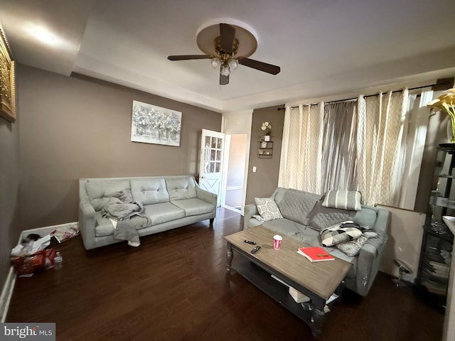 living room with ceiling fan and dark wood-type flooring