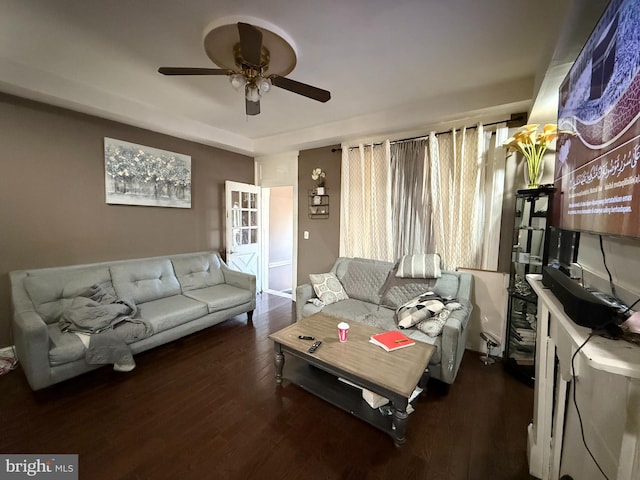 living room featuring ceiling fan and dark hardwood / wood-style floors