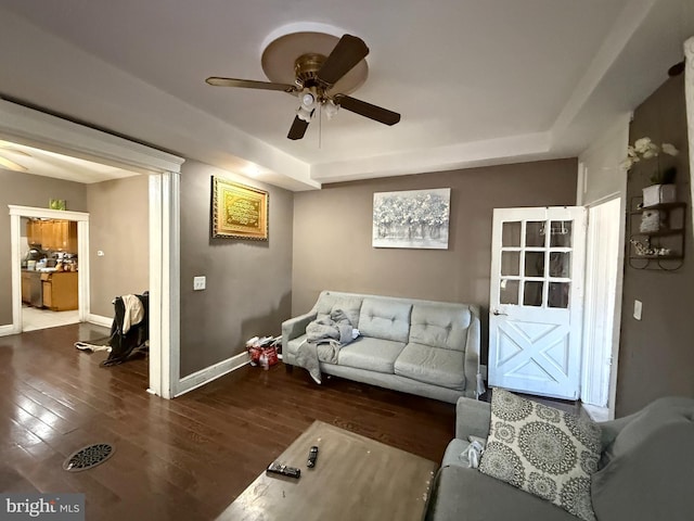 living room featuring ceiling fan and dark hardwood / wood-style floors