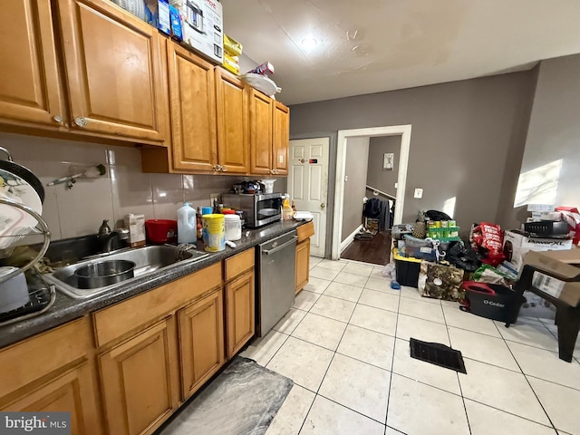 kitchen featuring decorative backsplash, appliances with stainless steel finishes, and light tile patterned floors