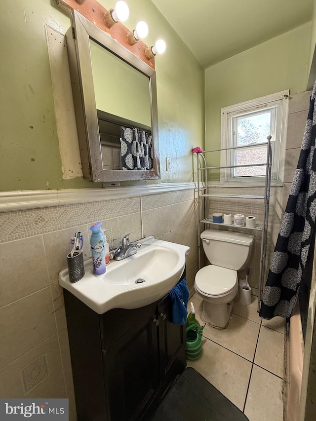 bathroom with tile patterned floors, vanity, tile walls, and toilet