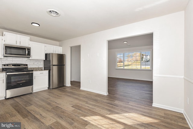 kitchen with decorative backsplash, white cabinetry, stainless steel appliances, and dark wood-type flooring