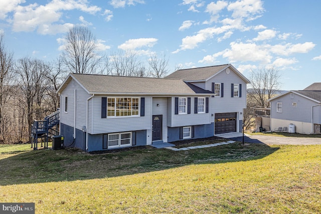 raised ranch with cooling unit, a front lawn, and a garage