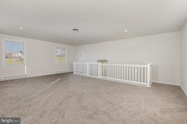 unfurnished room featuring light colored carpet and a baseboard heating unit