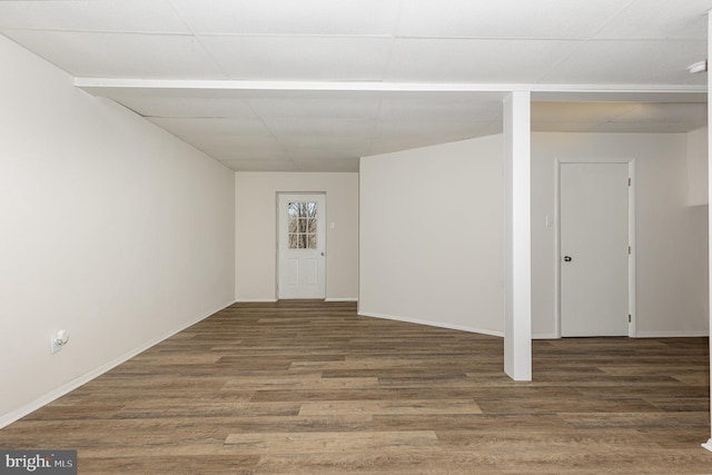 interior space featuring a drop ceiling and dark hardwood / wood-style floors