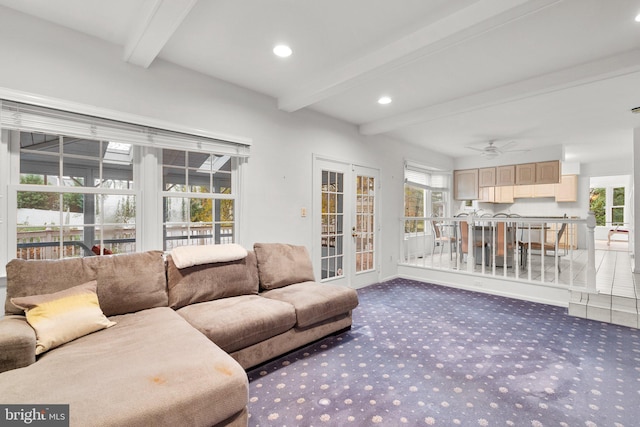 living room with beam ceiling, a wealth of natural light, and french doors