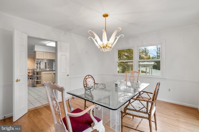 dining space with a chandelier, light hardwood / wood-style floors, and crown molding