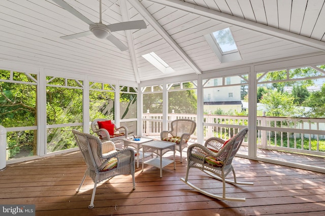 sunroom / solarium featuring lofted ceiling with skylight and ceiling fan