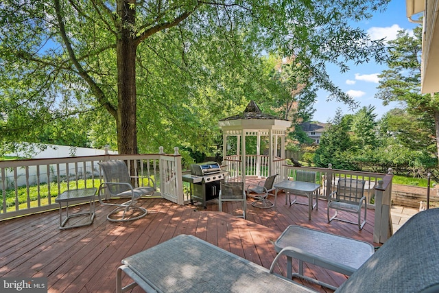 wooden terrace featuring a gazebo and a grill