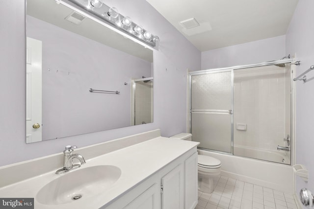 full bathroom with tile patterned floors, vanity, bath / shower combo with glass door, and toilet