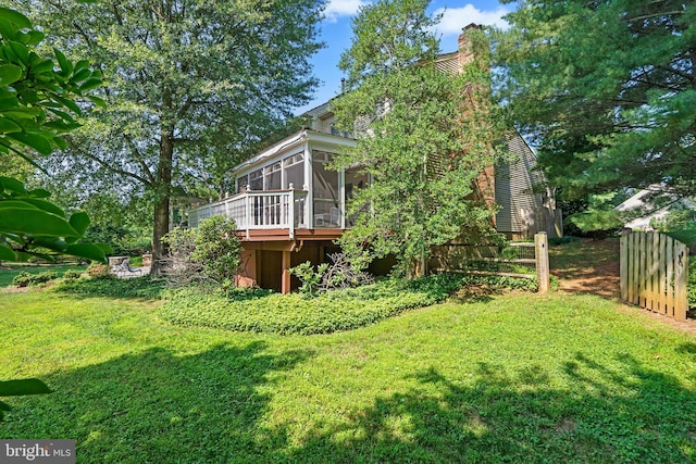 view of yard featuring a sunroom and a deck