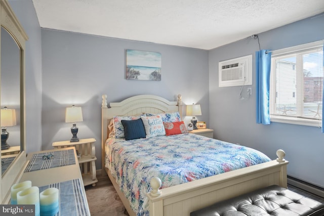 bedroom with a wall mounted air conditioner and a textured ceiling