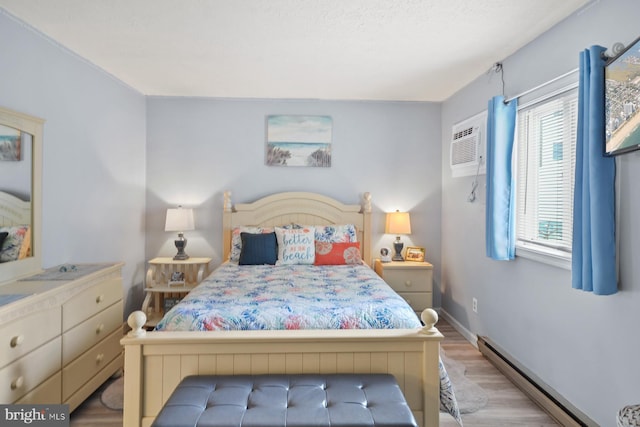 bedroom with a baseboard radiator, light hardwood / wood-style floors, and an AC wall unit