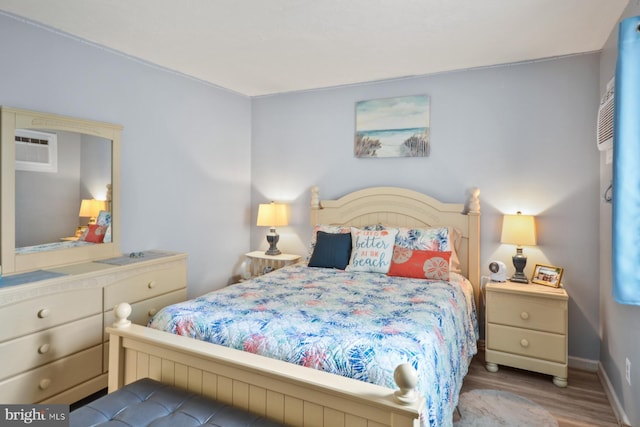 bedroom featuring a wall unit AC and light wood-type flooring