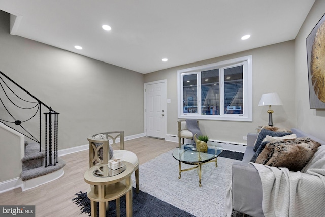 living room with light hardwood / wood-style flooring and a baseboard heating unit