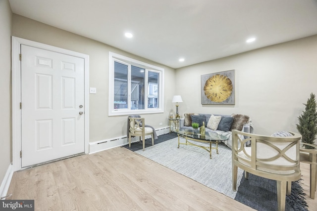 living room with light hardwood / wood-style flooring and a baseboard heating unit