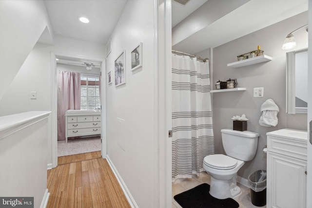 bathroom with hardwood / wood-style floors, vanity, and toilet