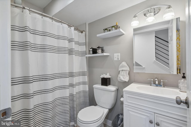 bathroom featuring walk in shower, vanity, and toilet