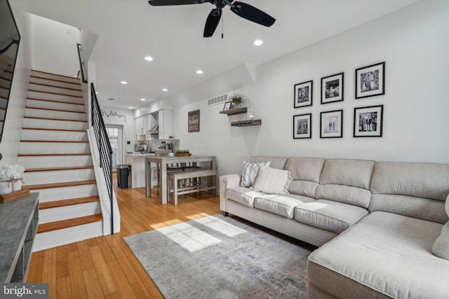 living room with ceiling fan and light hardwood / wood-style flooring